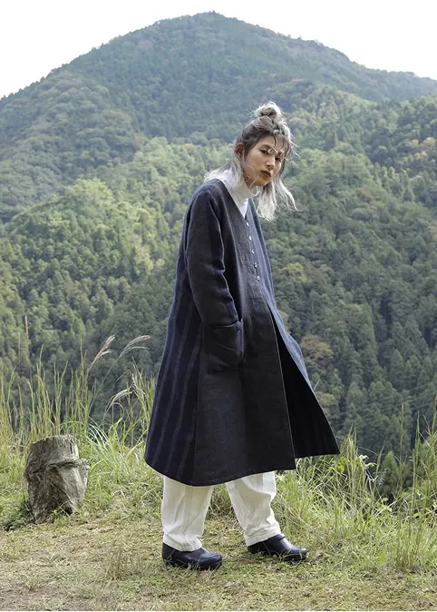 山の風景の中で播州織のコートを着た女性